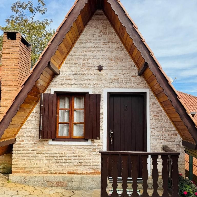 Fachada de um chalé alpino com tijolos e madeira